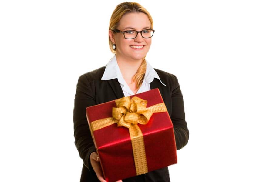 Eine Frau mit einem roten Geschenk lächelt in die Kamera